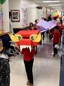 First Grade Chinese New Year Parade. Students walking under giant dragon