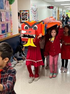 First Grade Chinese New Year Parade. Students walking under giant dragon